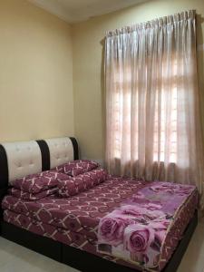 Ένα ή περισσότερα κρεβάτια σε δωμάτιο στο Homestay Hajah Rosnah