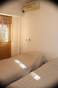 2 camas en una habitación con ventana en Universidad Maimonides Apartamento 2 amb en Buenos Aires