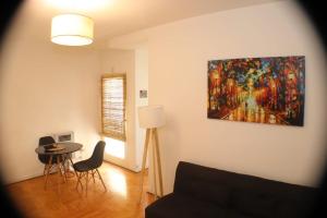 una sala de estar con una mesa y una pintura en la pared en Universidad Maimonides Apartamento 2 amb en Buenos Aires