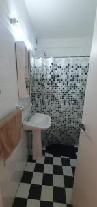 baño con lavabo y suelo a cuadros en blanco y negro. en Universidad Maimonides Apartamento 2 amb en Buenos Aires