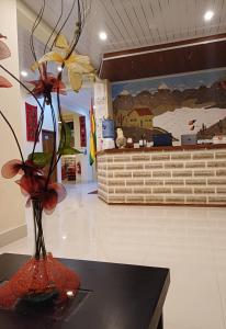 a vase with flowers on a table in a lobby at Hotel REY DAVID in Uyuni