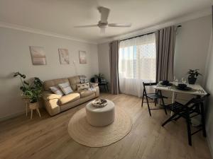 ein Wohnzimmer mit Sofa und Tisch in der Unterkunft Sussex Gem - Cozy apartment in the heart of Sussex in Sussex inlet