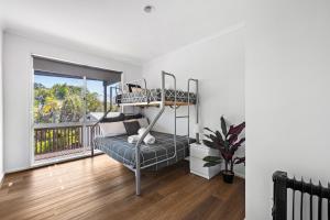 a bedroom with a bunk bed and a balcony at Valentine Sandcastles in Rye