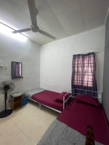 a bedroom with a red bed and a ceiling fan at AZ MUSLIM HOMESTAY in Seremban