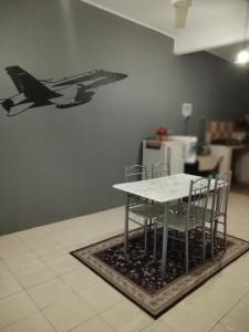 a table and chairs with a plane on the wall at AZ MUSLIM HOMESTAY in Seremban