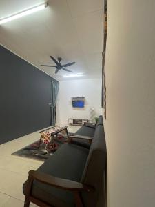sala de estar con ventilador de techo y sillas en AZ MUSLIM HOMESTAY, en Seremban