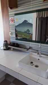 a bathroom counter with a sink and a mirror at Jasmin Homestay in Sanur