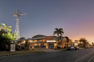um edifício com um moinho de vento ao lado de uma rua em Windmill Motel & Events Centre em Mackay