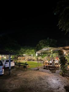 Ein Mann, der an einem Picknicktisch unter einem Zelt sitzt. in der Unterkunft The Legend Homestay. in Mae Ai Chiang Mai