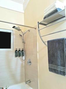uma casa de banho com um chuveiro, um lavatório e uma toalha em Sidona Suite: Hillview city vibes. Airport 15 mins. Attractions nearby em Montego Bay