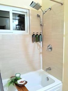 uma casa de banho com um chuveiro, uma banheira e um lavatório. em Sidona Suite: Hillview city vibes. Airport 15 mins. Attractions nearby em Montego Bay