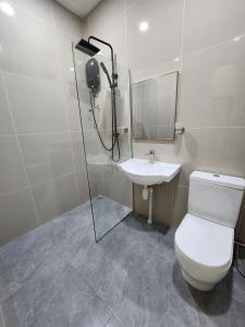 a bathroom with a toilet and a sink at One Point Hotel in Kuching