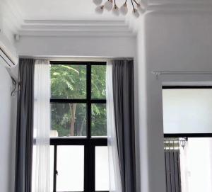 Zimmer mit einem Fenster mit Vorhängen und einer Lampe in der Unterkunft Shanghai Garden Apartment - Near Downtown Wukang Road in Shanghai