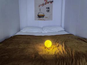a bed with a yellow light on top of it at Shanghai Garden Apartment - Near Downtown Wukang Road in Shanghai