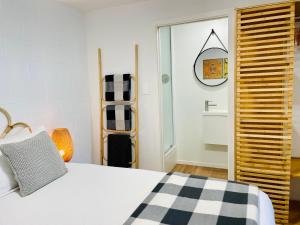 um quarto com uma cama com uma almofada preta e branca em Breezy Ocean - The perfect getaway em Mount Maunganui