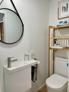 a bathroom with a sink and a mirror on the wall at Breezy Ocean - The perfect getaway in Mount Maunganui