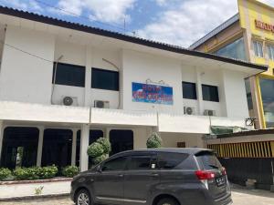 a minivan parked in front of a building at Hotel Surya Citra Jogja A Mitra RedDoorz in Timuran