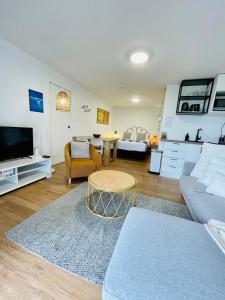 a living room with a couch and a table at Breezy Ocean - The perfect getaway in Mount Maunganui