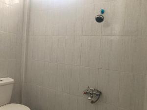 W łazience znajduje się prysznic wyłożony kafelkami i toaleta. w obiekcie Hotel Surya Citra Jogja A Mitra RedDoorz w mieście Timuran