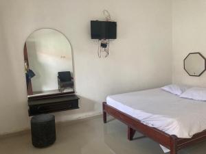 sypialnia z łóżkiem, lustrem i telewizorem w obiekcie Hotel Surya Citra Jogja A Mitra RedDoorz w mieście Timuran