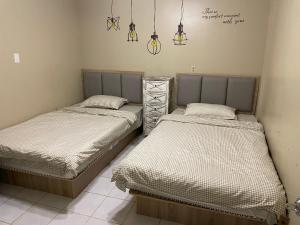 two beds sitting next to each other in a room at DreamHouse in Ngerbodel +3 photos