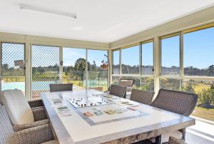 a dining room with a large table and chairs at Noble Willow Estate in Lovedale