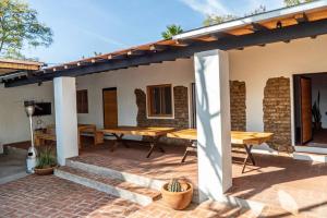 a patio with wooden tables and a roof at Casa Cecilia Lodging House in Oaxaca City