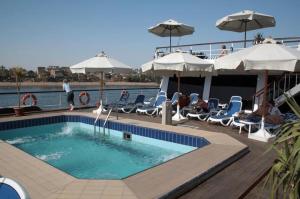 una piscina con sillas y sombrillas en un barco en مركب ريفر River Boat en El Cairo