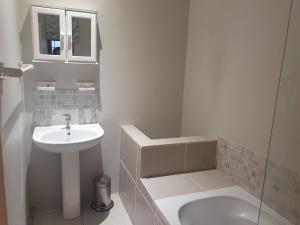 a white bathroom with a sink and a toilet at Northlands Manor in Durban
