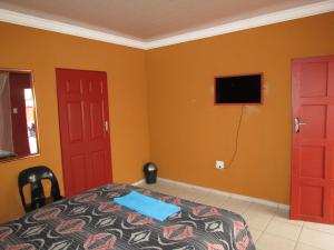 a bedroom with two red doors and a bed at Cozy Queen-Bed Apartment in Hammanskraal 