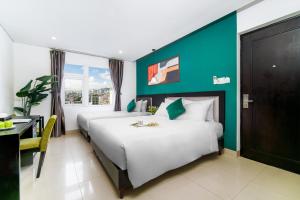 a hotel room with two beds and a desk at Golden Star Hotel by THG in Da Nang