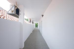 un corridoio bianco di una casa con pareti bianche di RedDoorz near Jalan Cikini a Giacarta