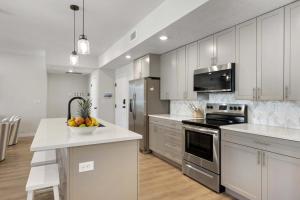 a kitchen with white cabinets and a bowl of fruit on a counter at Primo Lagoon Retreat condo in St. George