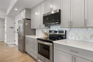 a kitchen with stainless steel appliances and white cabinets at Primo Lagoon Retreat condo in St. George