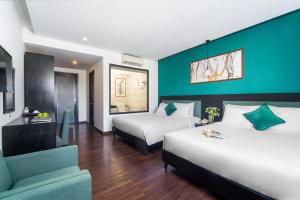 una camera d'albergo con due letti e un divano di Golden Star Hotel by THG a Da Nang