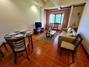 ein Wohnzimmer mit einem Tisch und einem Sofa in der Unterkunft Luxury 1 BR Suite Malarayat Lipa in Lipa
