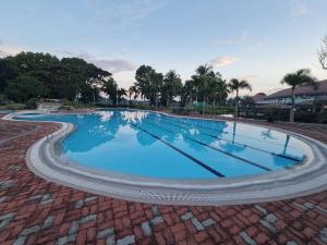 a large swimming pool with blue water at Luxury 1 BR Suite Malarayat Lipa in Lipa