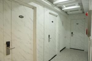 korytarz z białymi marmurowymi ścianami i drzwiami w obiekcie Mangsang Beach Pension w mieście Gangneung