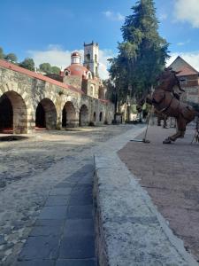 una estatua de un caballo de pie junto a una calle en Cabaña Los Ángeles, en Huasca de Ocampo