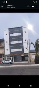 a building with a car parked in front of it at Lugar Encantador Con Estacionamiento Gratuito 1 in Olavarría