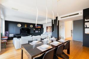 a dining room and living room with a table and chairs at Splendid house Buenos Aires Piazza Lima in Milan