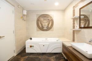 Baño blanco con lavabo y espejo en Family&PetFriendly 5BHK With Jacuzzi @BanjaraHills, en Hyderabad