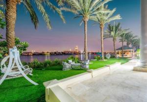 a park with palm trees and a body of water at Pristine Paradise Villa In Palm Jumeirah in Dubai