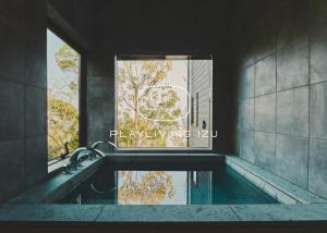 baño con lavabo, ventana y espejo en Playliving IZU - A ocean view villa with Onsen, en Ito