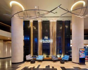 a lobby of a hotel with blue chairs and columns at Anya Premier Hotel Quy Nhon in Quy Nhon