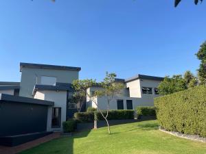 a house with a small tree in the yard at Hill Luxury Cottage in Roodepoort