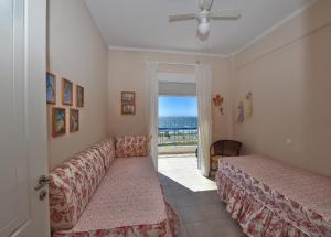 a bedroom with a bed and a couch and a window at Balcony of the Ionian Sea in Paralia Kanaliou