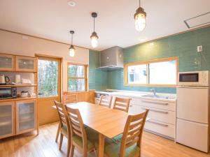 a kitchen with a wooden table with chairs and a sink at KuDo's Lodge - Vacation STAY 85093 in Chikuni