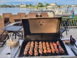 a grill on a deck with sausages and bacon at Vanderbilt Beach 3br/3ba condo in Naples