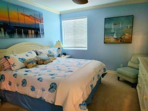 a blue bedroom with a bed and a chair at Vanderbilt Beach 3br/3ba condo in Naples
